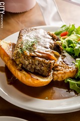 PHOTO BY MARK CHAMBERLIN - The open-faced meatloaf sandwich, which has a rice-based filler and is studded with fresh mozzarella and beef, with caramelized onion gravy with parsley on top.