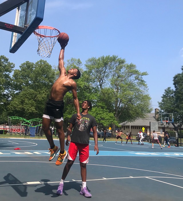 Maurice "Mo" McKinney, 16, reaches for a dunk with an assist from his brother, Christian Harmon, 15, at Cobb's Hill Park. - PHOTO BY DAVID ANDREATTA