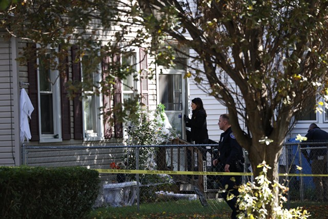 A Rochester Police Department Major Crimes investigator enters 278 Pennsylvania Ave., where a large party had been held Friday night into Saturday morning. Early Saturday, Jaquayla Young and Jarvis Alexander, both 19, were killed in a mass shooting that wounded 14 other people. - PHOTO BY MAX SCHULTE