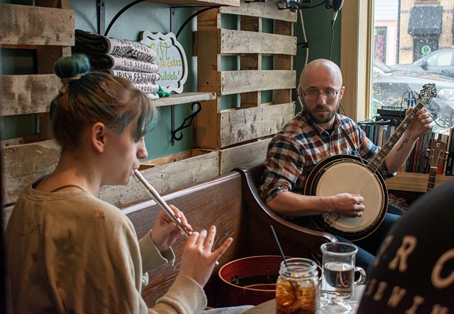 Peri Malone plays the tin whistle with session leader Sean Rosenberry on the banjo at Barry's in Webster. - PHOTO BY JACOB WALSH