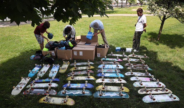Instructors from the M.K. Gandhi Institute, Skateistan, and Salad Days arrange donated decks, sneakers, helmets, and other safety equipment for students to use at the ROC City Skatepark. - PHOTO BY MAX SCHULTE