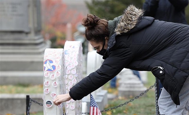 Abby Richards, 20, of Victor, places her "I Voted" sticker on Susan B. Anthony's grave. - PHOTO BY MAX SCHULTE