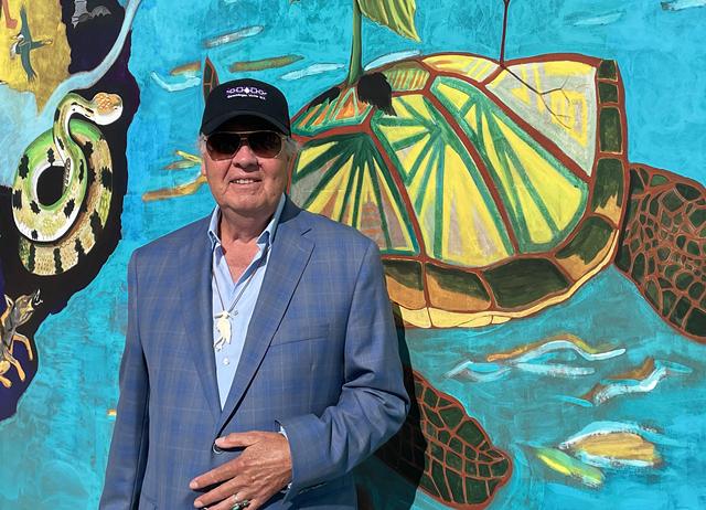 Artist G. Peter Jemison stands in front of his "Water is Life" mural, which was installed on the Floreano Convention Center facing the Genesee River. - PHOTO BY REBECCA RAFFERTY