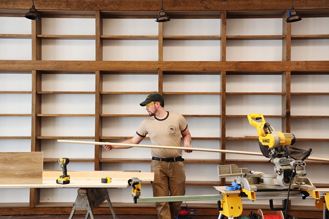 Nick Bober, an installer with Carver Creek Woodworks, builds shelves at Bleak House Books. The store is now expected to open in June. - PHOTO BY MAX SCHULTE