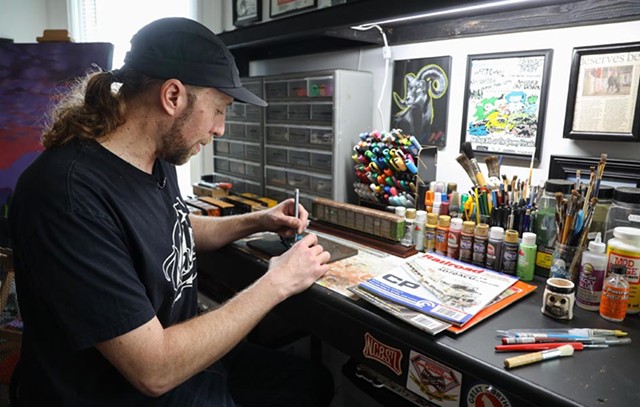Alex Price, 39, used to regularly graffiti real trains. Now, he is more likely to be plying graffiti to models in his home art studio on South Union Street. - PHOTO BY MAX SCHULTE