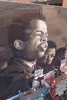 Painters depict a young John Lewis in the mural "I Am Speaking," at 49 State St. in downtown Rochester.